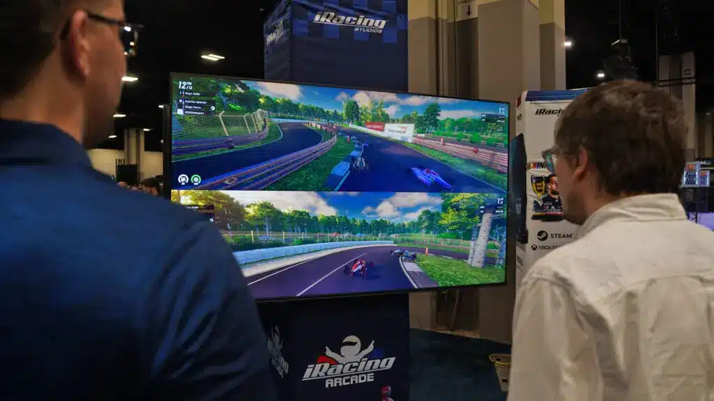iRacing Arcade display screen showing a split-screen racing game with two different car perspectives