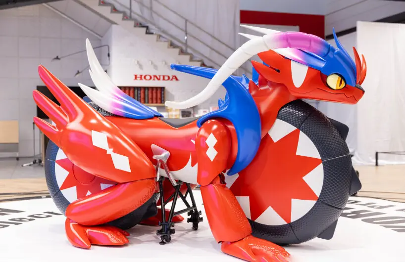 Life-size Koraidon motorcycle sculpture displayed in front of a Honda logo