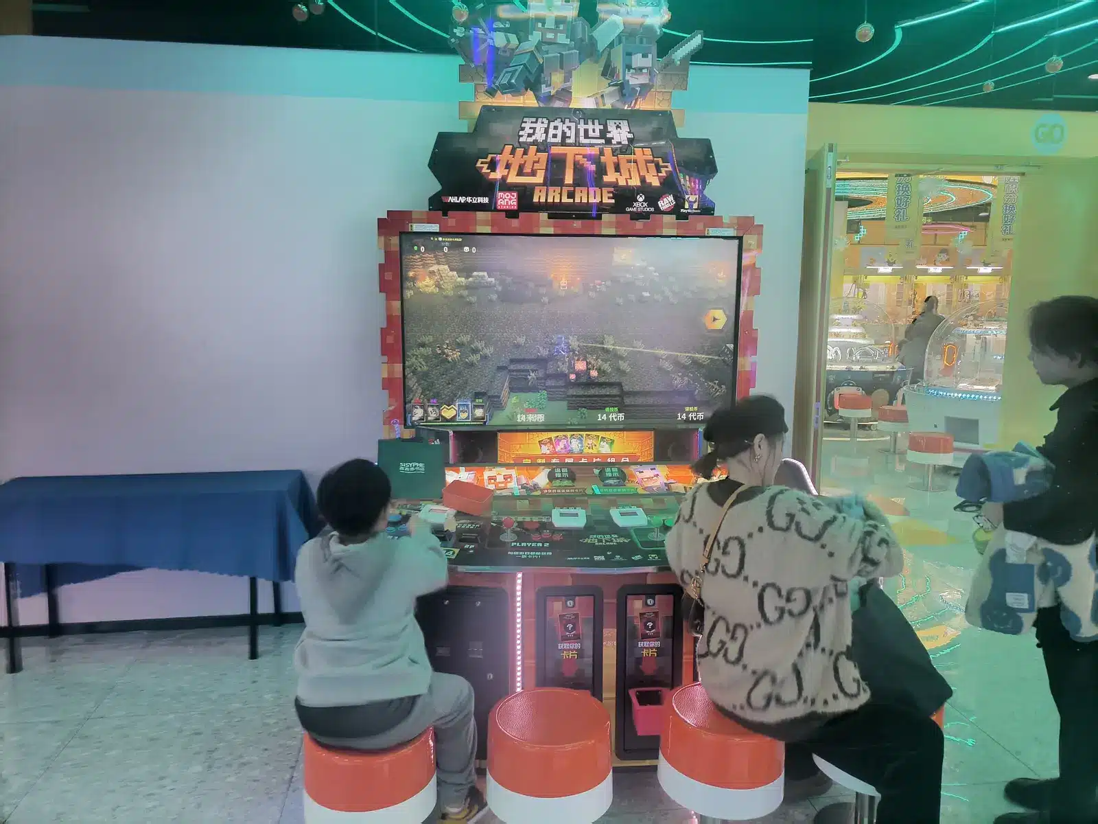 Eine Arcade-Spielstation von Minecraft Dungeons mit Spielern in einer Spielhalle.