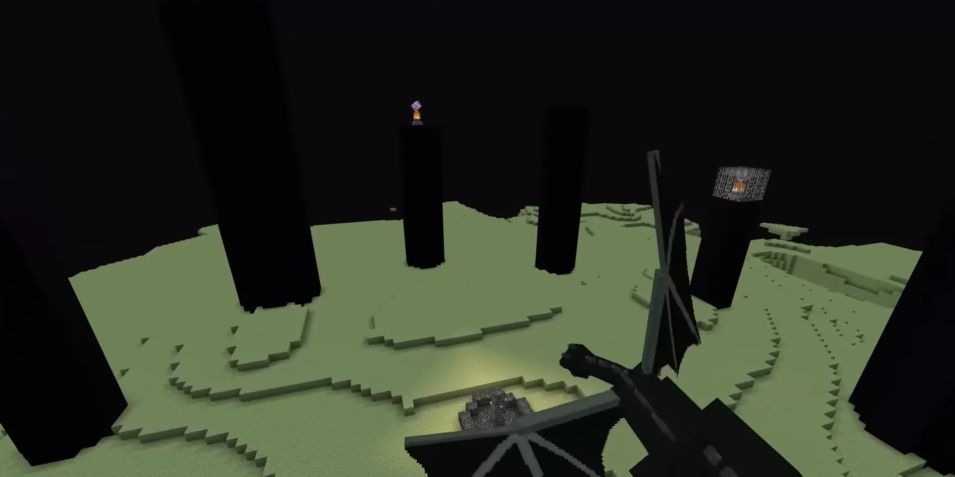 Ein Screenshot aus der Minecraft-Dimension 'The End' mit gelblichen Blöcken und schwarzen Obsidiansäulen.